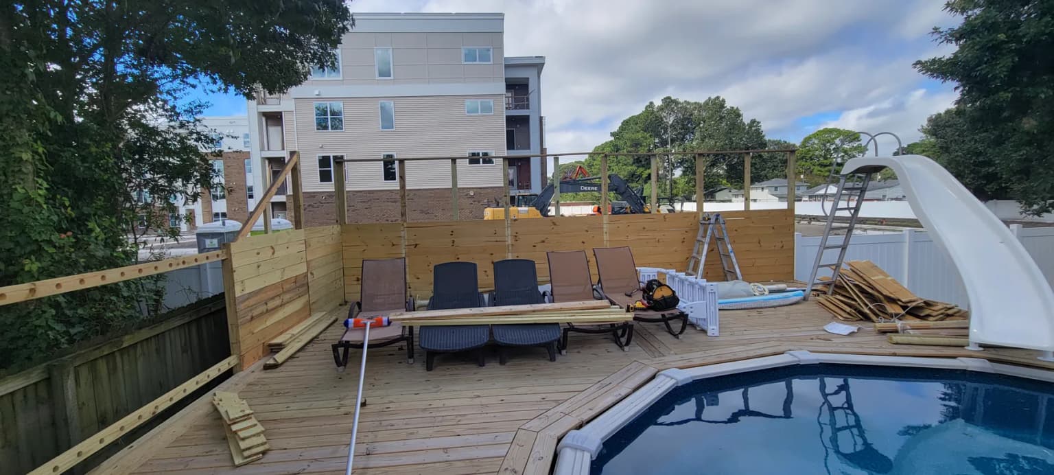 Deck, fence, lumber, and tools staged for grouped handyman work
