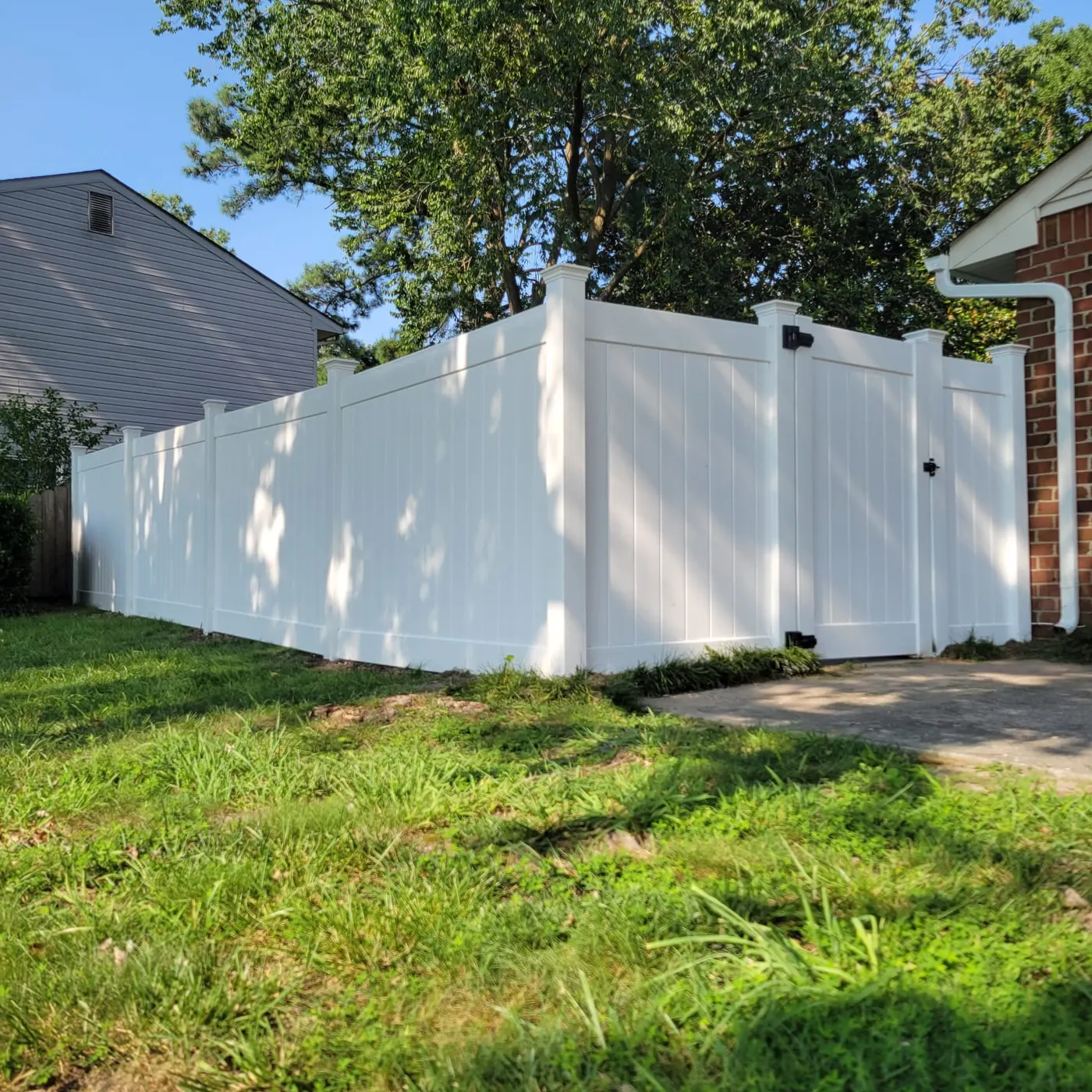 White vinyl privacy fence and gate White vinyl privacy fence with gate beside a Hampton Roads driveway