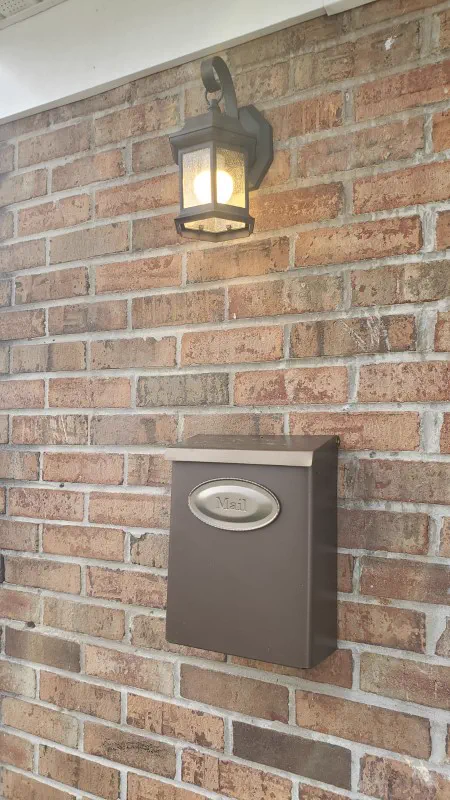 Illuminated outdoor wall lantern mounted on brick